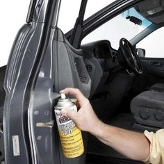 a man is opening the door of a car with a can of cleaner on it