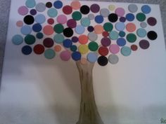 a tree made out of colored circles sitting on top of a white board with gray carpet