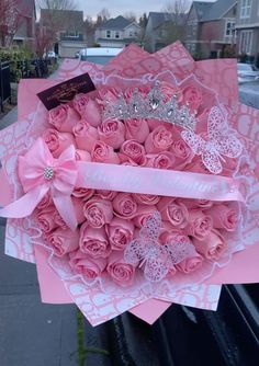 a bouquet of pink roses with a tiara on top