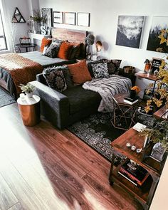 a living room filled with lots of furniture next to a bed and table in front of a window