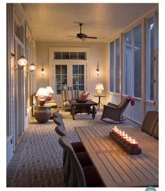 a room with many chairs and lights on the ceiling, along with a table that has candles in front of it