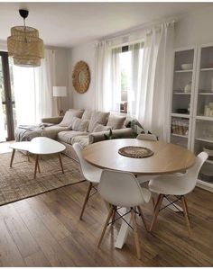 a living room filled with furniture and a wooden table in front of a sliding glass door