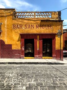 an old building with two doors and a sign on the front that says bar san miguel