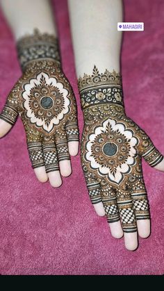 two hands with henna designs on them