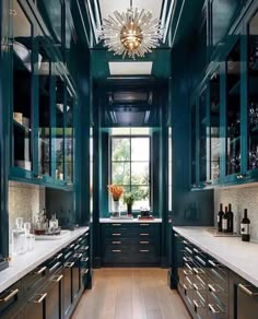 a large kitchen with green cabinets and white counter tops, along with wooden flooring