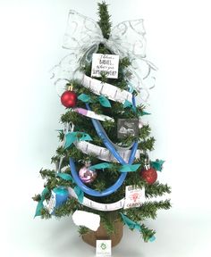 a small christmas tree decorated with ribbons and ornaments