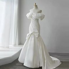 a white wedding dress on display in front of a window