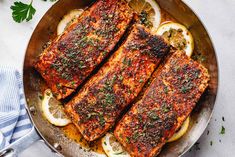 grilled salmon in a pan with lemons and parsley