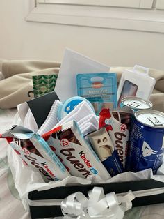 a basket filled with snacks and drinks on top of a bed