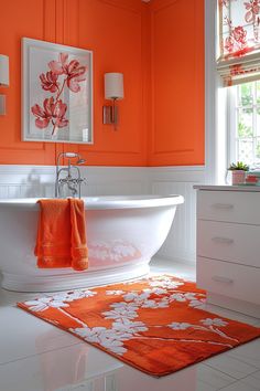 an orange and white bathroom with flowers on the bathtub, rugs and towels