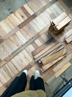 a person standing on top of a wooden floor next to pieces of wood that have been cut in half