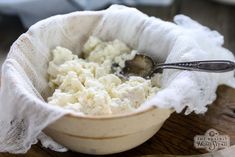 a bowl filled with mashed potatoes on top of a wooden table