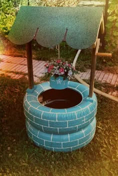 an outdoor fountain made out of old tires and some flowers in the potted planter