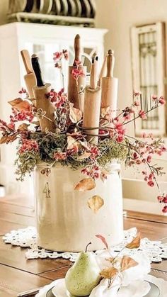 a vase filled with lots of different types of utensils on top of a wooden table