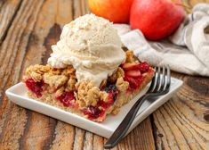 a piece of pie on a plate with ice cream and fruit in the back ground