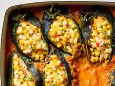 an overhead view of some stuffed peppers in a casserole dish with corn on the cob