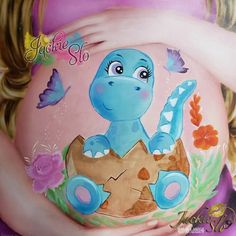 a painting of a pregnant woman with blue dinosaur on it's stomach and butterflies around her belly