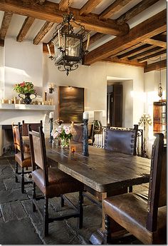 a dining room table and chairs in front of a fireplace