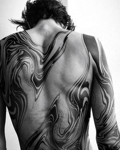 the back of a man with tattoos on his body