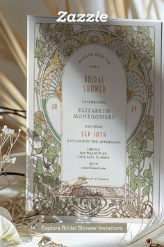 an ornate wedding card with flowers and foliage in the background, on top of a table