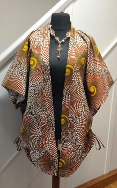 Stylish handmade Ankara kimono. Length 38. One size fits all. Pull string on both sides of the kimono which can be used to pull the length in from th sides,to give it's unique look.  2 Patched pocket  in front. Pair beautifully with a pair of leggings,pants,or bodycon dress to elevate your style. Available in wholesale. Feel free to message me if you need more  help. Kimono Tops Designs, Brown Wrap Kimono For Spring, Spring Brown Wrap Kimono, Brown Kimono With Kimono Sleeves For Fall, Traditional One-size Kimono With Kimono Sleeves, Brown Kimono With Kimono Sleeves For Spring, Fall Kaftan With Kimono Sleeves, Multicolor Handmade Kimono With Kimono Sleeves, Handmade Multicolor Kimono With Kimono Sleeves