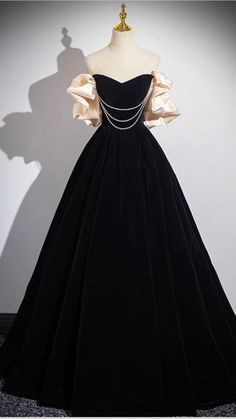 a black dress on display in front of a white wall