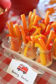 small jars filled with carrots and pickles on top of a checkered table cloth