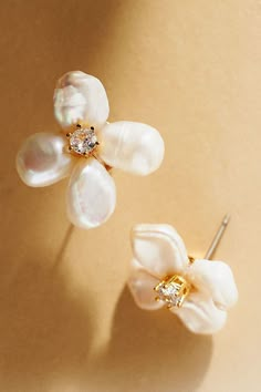 two pairs of earrings with pearls and diamonds on the top one is white, the other is gold