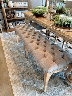 a bench sitting on top of a rug next to a table