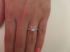 a woman's hand with a diamond ring on it