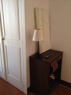 a lamp is sitting on top of a small table in front of a closet door