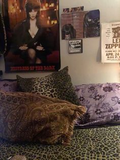 a bed with leopard print pillows and pictures on the wall above it, along with other decorative items