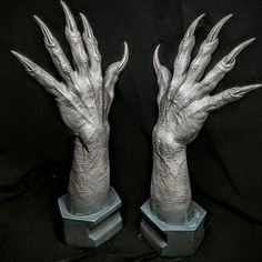 two fake hands that are on top of some glass bases with their claws spread out