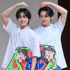 two young men standing next to each other with their hands on their head and one wearing a t - shirt that has cartoon characters on it