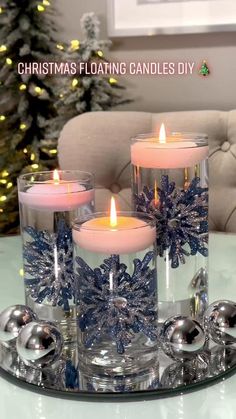 three candles sitting on top of a glass tray next to a christmas ornament