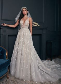 a woman in a wedding dress standing next to a blue couch