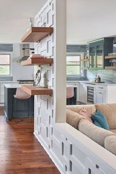 a living room filled with furniture next to a kitchen