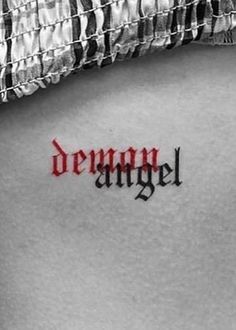 a woman's lower back tattoo with the word demon on it in red ink