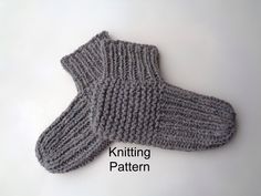 a pair of gray knitted mittens sitting on top of a white table with the words knitting pattern below it