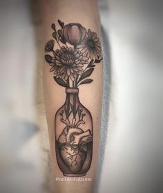 a black and white photo of a heart in a vase with flowers on the arm