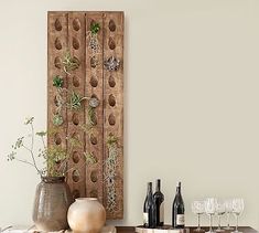 a table with vases and bottles on top of it next to a wall hanging