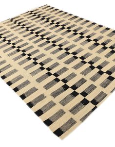 a black and white rug with squares on the bottom is shown in full view, as if it was made out of wool