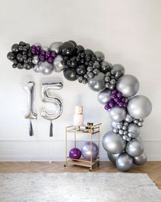 an arch made out of balloons with the number fifteen on it and some other decorations