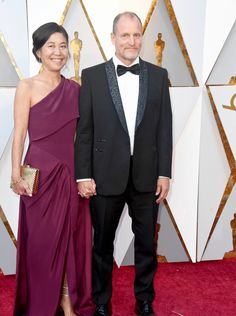 an older man and woman in formal wear on the oscars red carpet