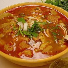 a yellow bowl filled with soup and vegetables