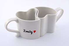 two white coffee mugs with the word family printed on them and heart shaped handles