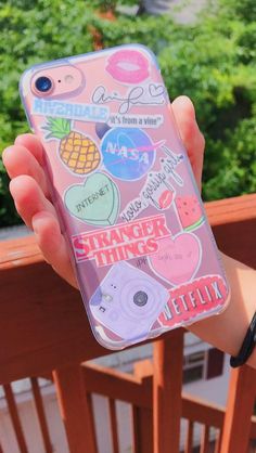 someone holding up their phone case with stickers on it