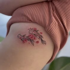 a woman's stomach with a tattoo on the side of her body and flowers