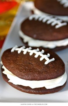 chocolate football cookies with white frosting on a plate