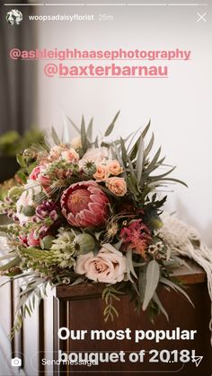 a bouquet of flowers sitting on top of a wooden box next to a wall with the words, our most popular bouquet of 2018